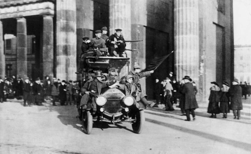 Revolutionäre Soldaten mit der Roten Fahne am 9. November vor dem Brandenburger Tor. Bundesarchiv, Bild 183-B0527-0001-810 / Unbekannt / CC-BY-SA 3.0